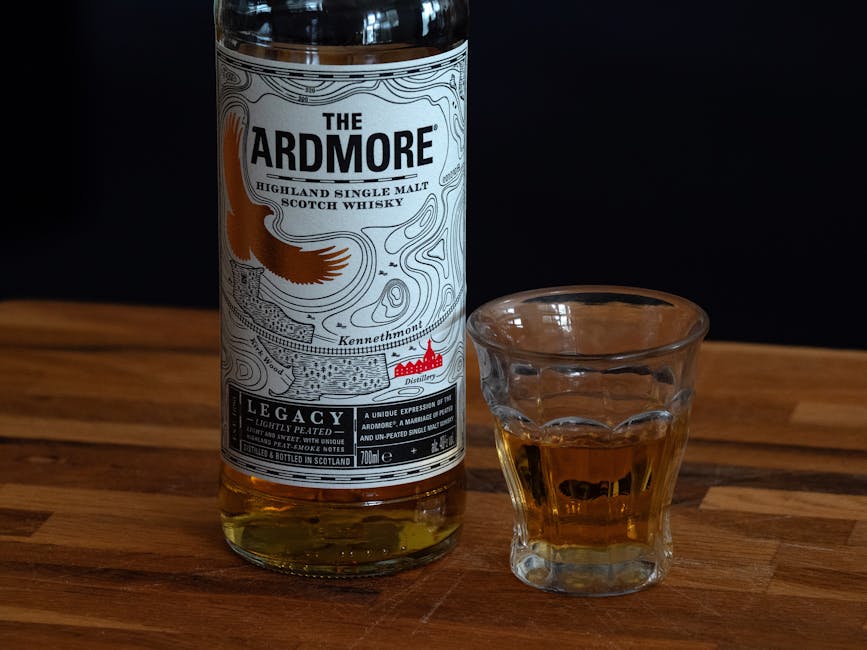 Verre de whisky ambré posé sur une table en bois